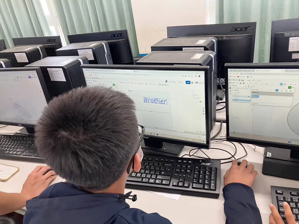 孩子坐在電腦前,螢幕上是正在用 TinkerCAD 畫的 3D 圖形